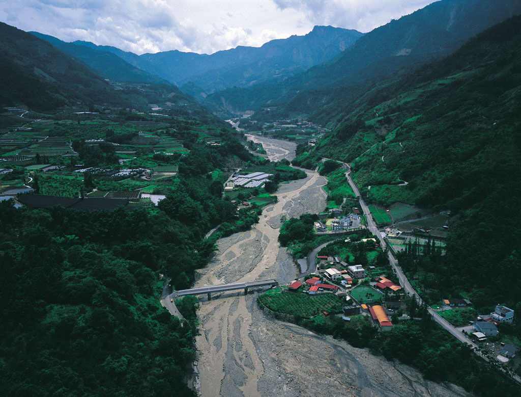 照片8  2004年七二水災期間洪水沖毀隆華橋(照片中間偏右處即為九二一地震後第二次重建的隆華國小)